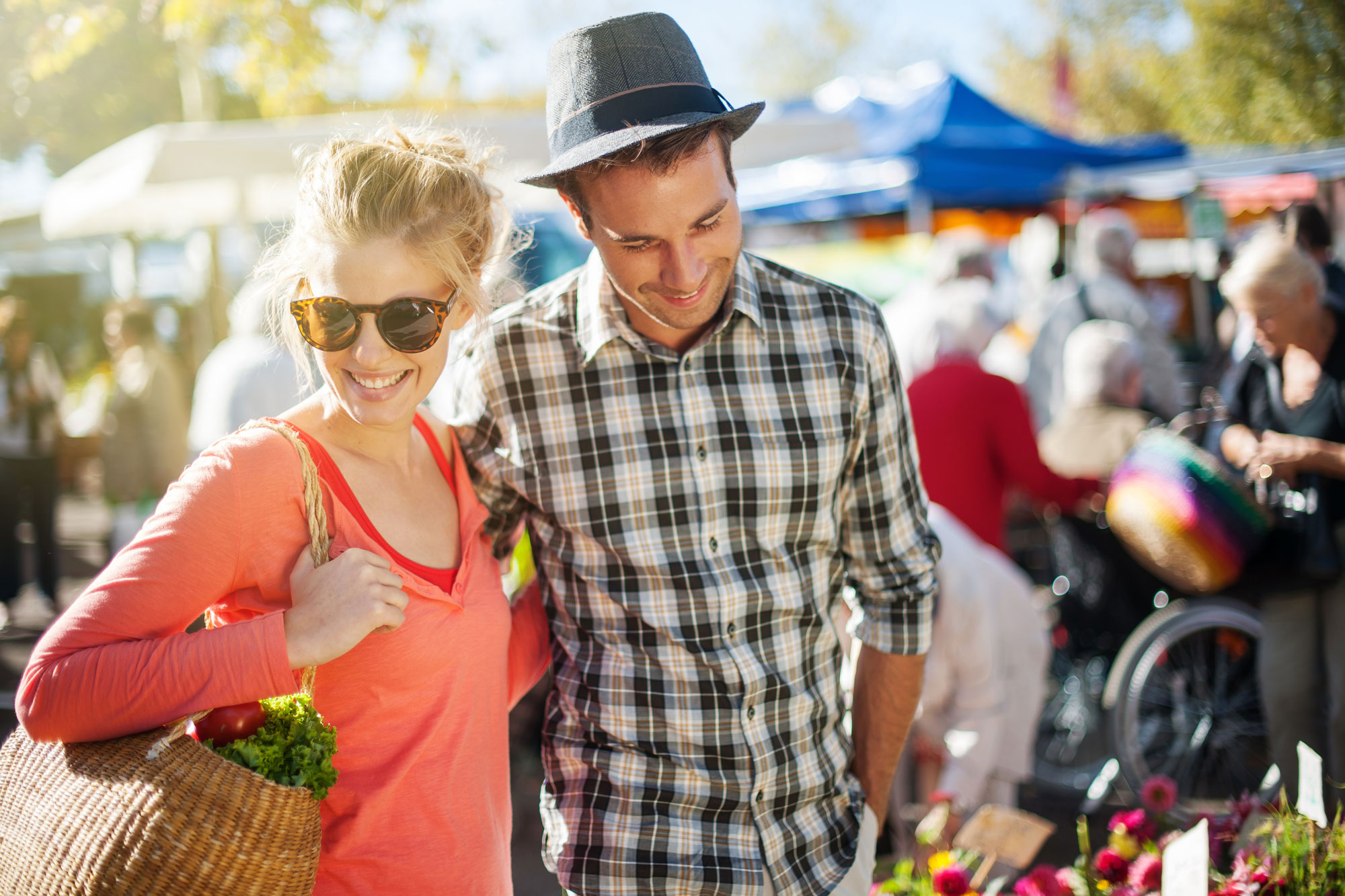 happy couple with casual clothes holding together side by side and enjoying outside at the market