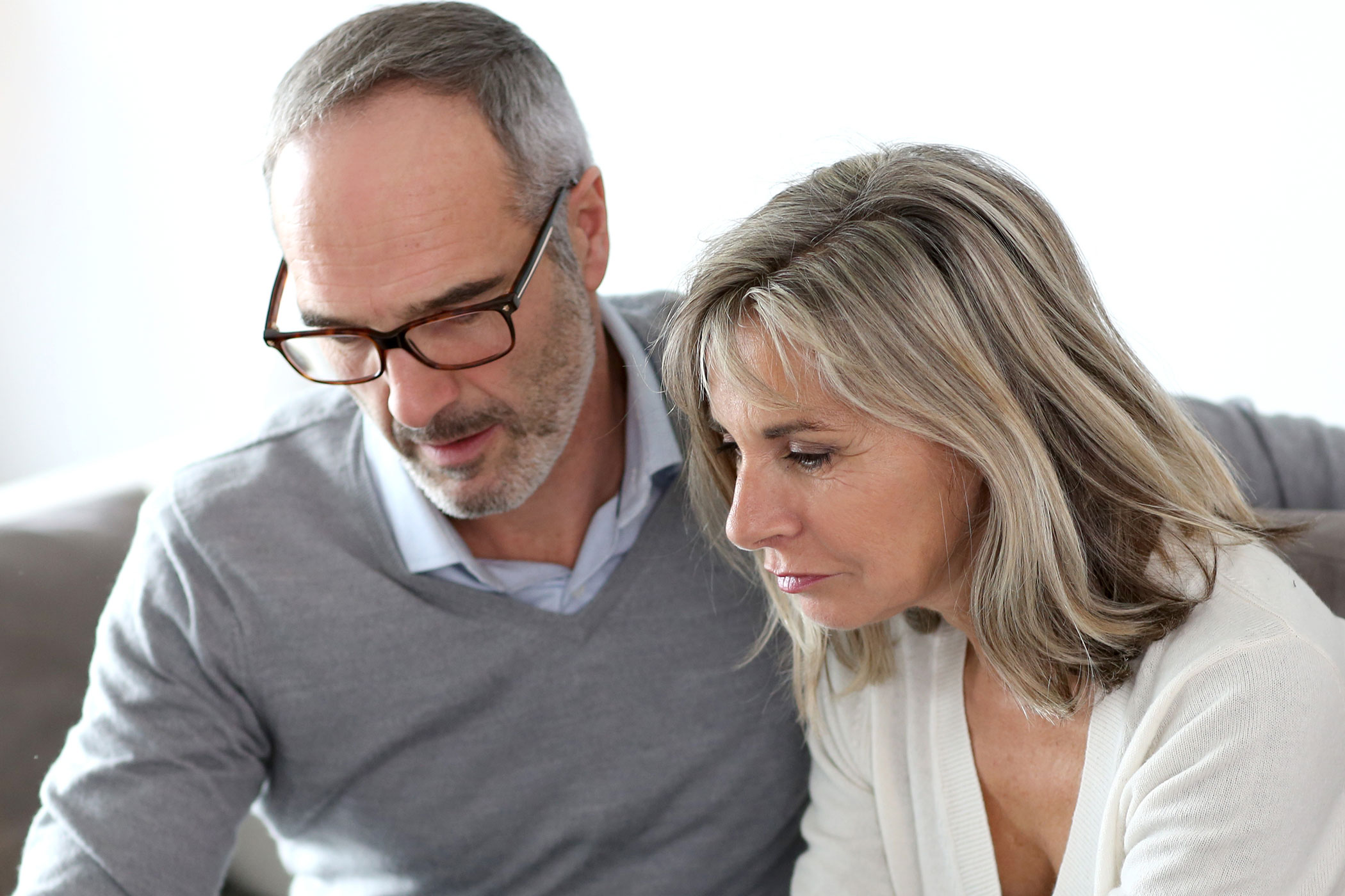 A middle age couple in light cozy sweater discussing together